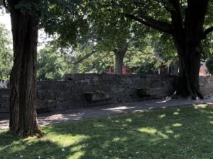Memorial wall with two trees in front