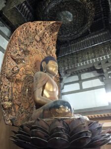 Side view of carved Amida Budha figure