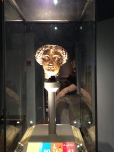 Golden statue head in glass case