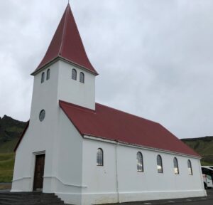 Phot of a small white church with a red roof