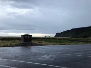 Photo of parking lot with sea stacks in distance